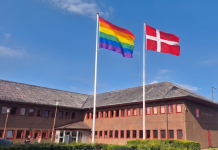 Salomonisk Dom i flagstrid: To flagstænger foran rådhuset dannebrog og regnbueflag ved rådhuset. Foto: AI-manipuleret billede