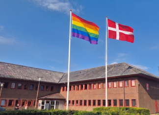 Salomonisk Dom i flagstrid: To flagstænger foran rådhuset dannebrog og regnbueflag ved rådhuset. Foto: AI-manipuleret billede